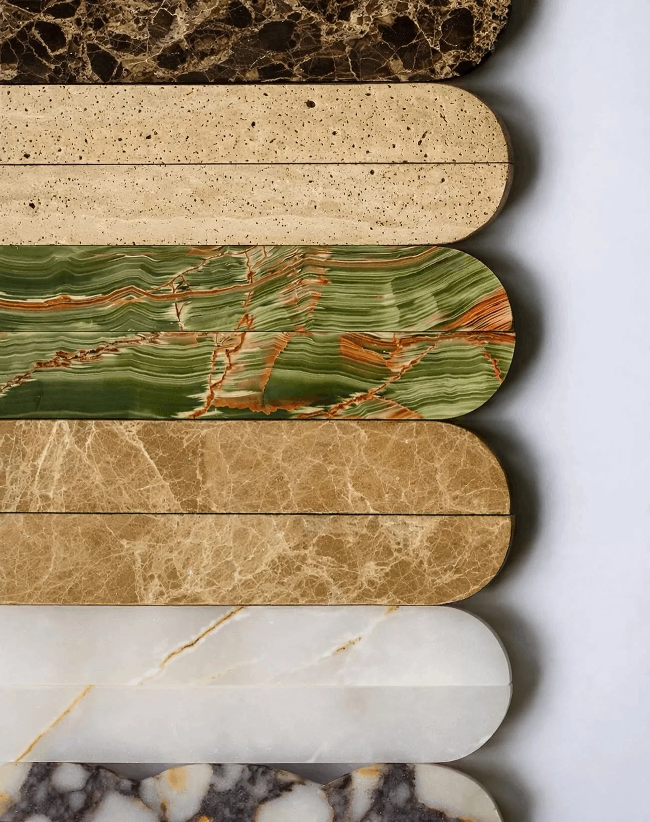Uncut stone pulls stacked side by side: brown Emperador marble, cream travertine and green onyx