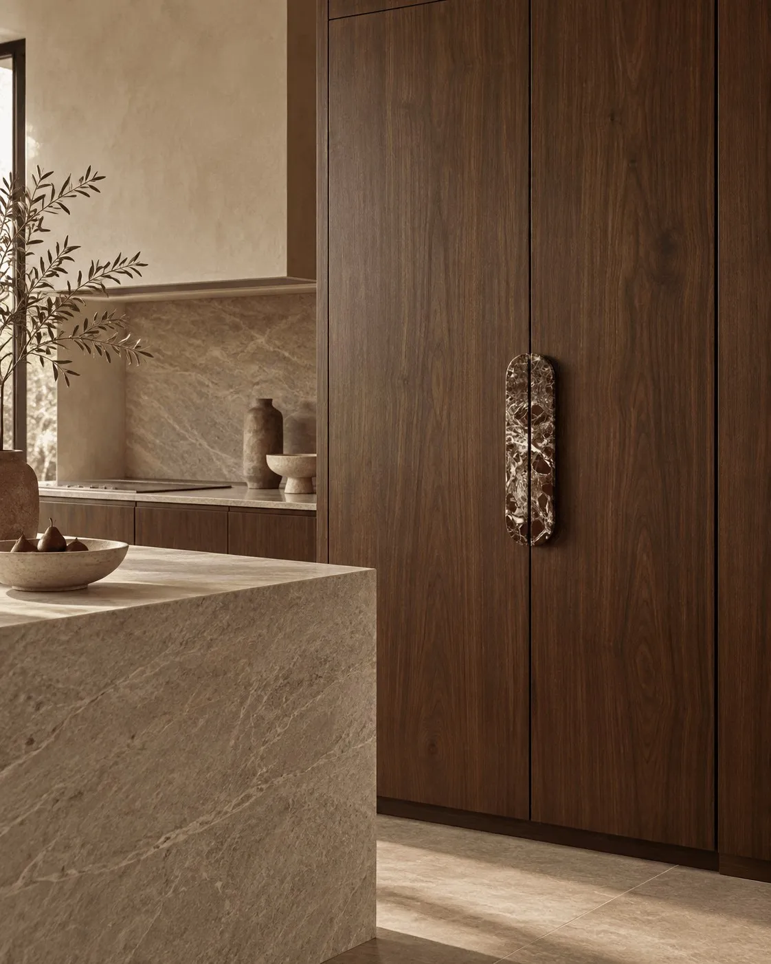 An Oval Pull in red Rosso Levanto marble on full-height walnut doors, beside a stone island